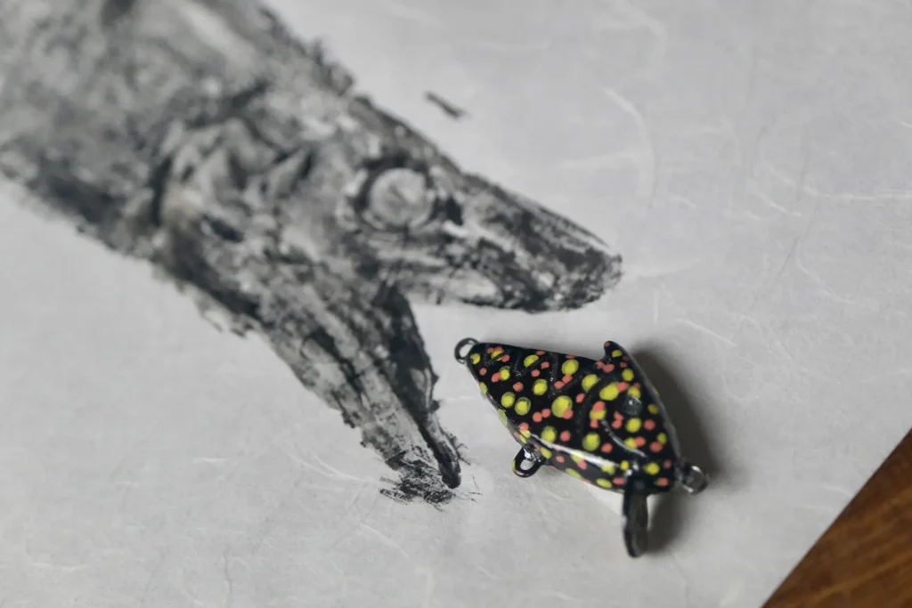 CS Nano Shark – mała przynęta spinningowa do połowu okoni, kleni, jazi i pstrągów, w tle gyotaku Custom Shark